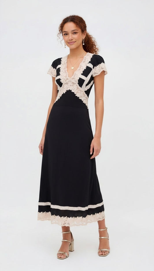 Model wearing a black Rixo satin midi dress with cream lace trim on the V-neck, sleeves, and hem from S T Y L E L I B R A R Y