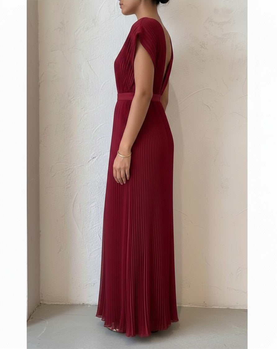 S T Y L E L I B R A R Y ruby red pleated maxi gown with a plunging neckline and open back, side view.